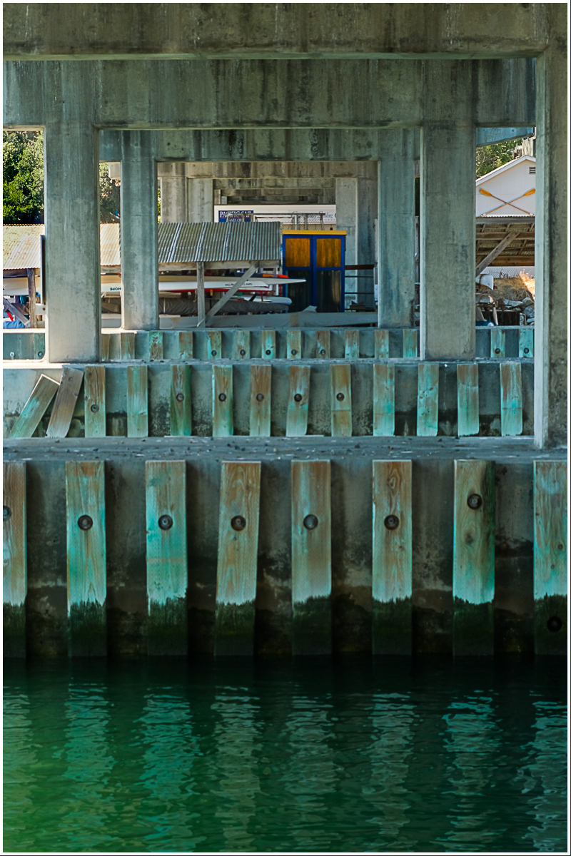 Orange and blue door beneath a&nbsp;bridge