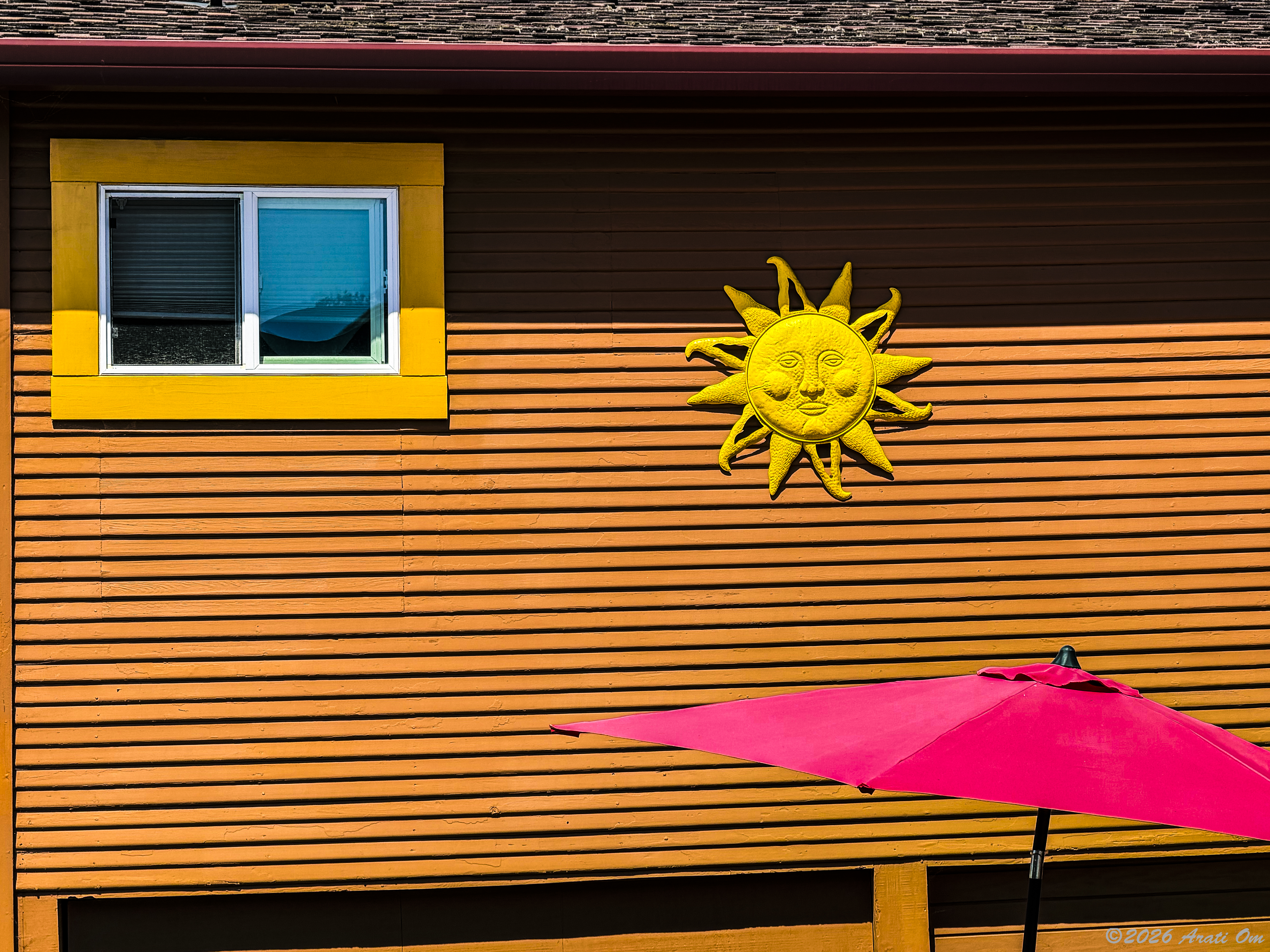 The sun, a window and a red parasol